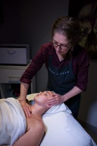 esthetician giving client a facial