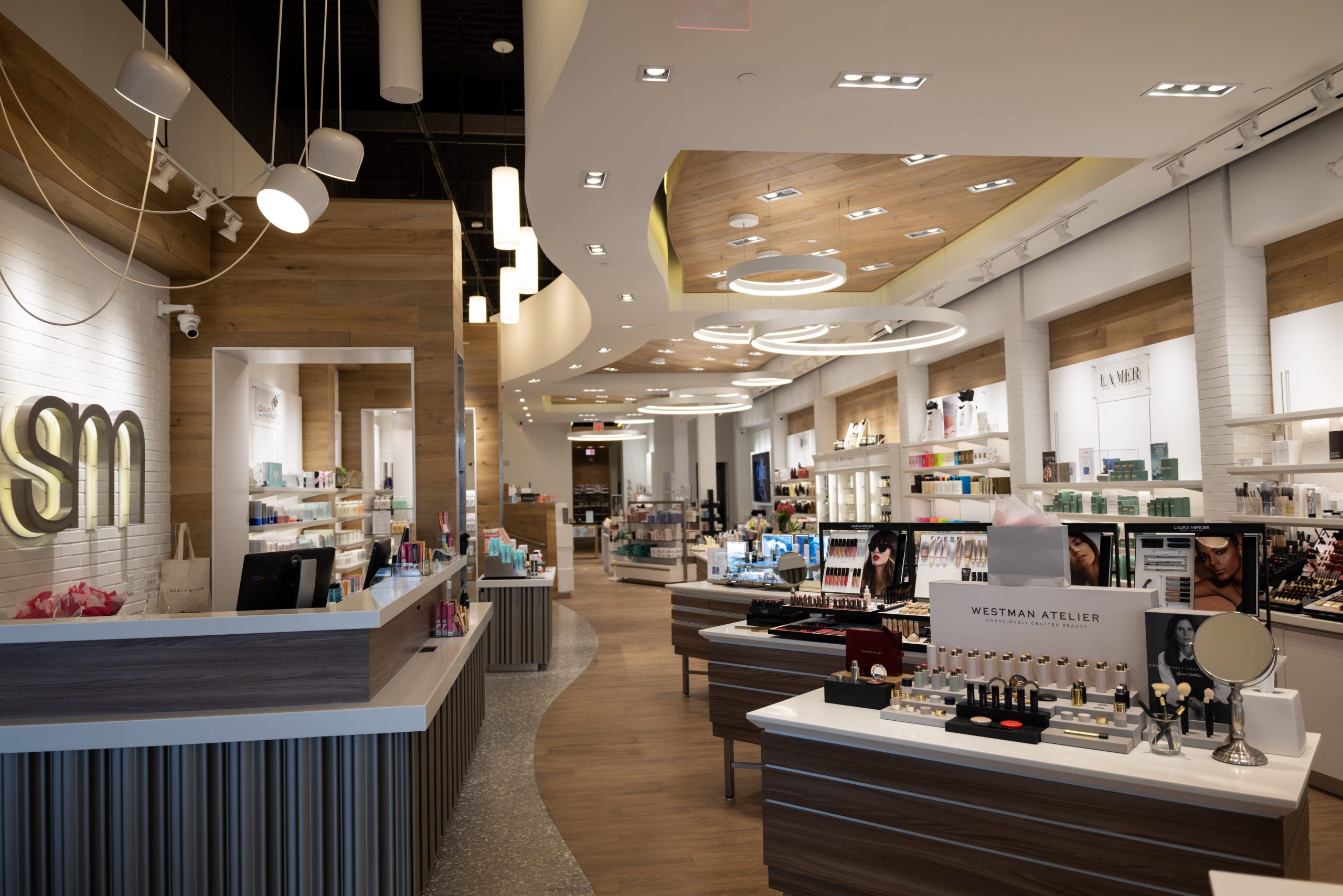 Modern luxury beauty boutique interior with makeup displays and skincare counters.